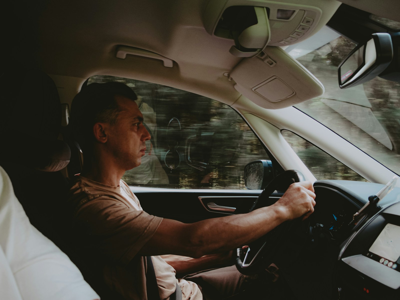 A man sitting in a car with a steering wheel